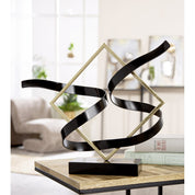 Swing of balance black and gold metal sculpture